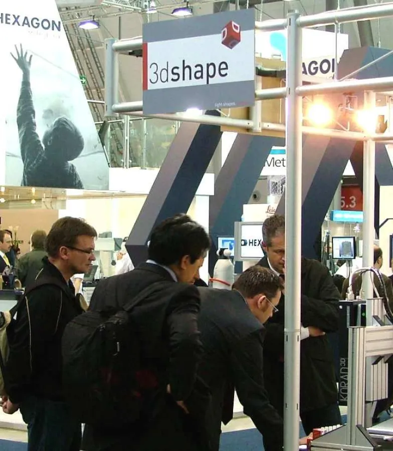 Besucher am Messestand der 3D-Shape GmbH. Produktentwickler Reinhard Gross (2. v.r.) erläutert die Funktion seines optischen Sensors KORAD3D.