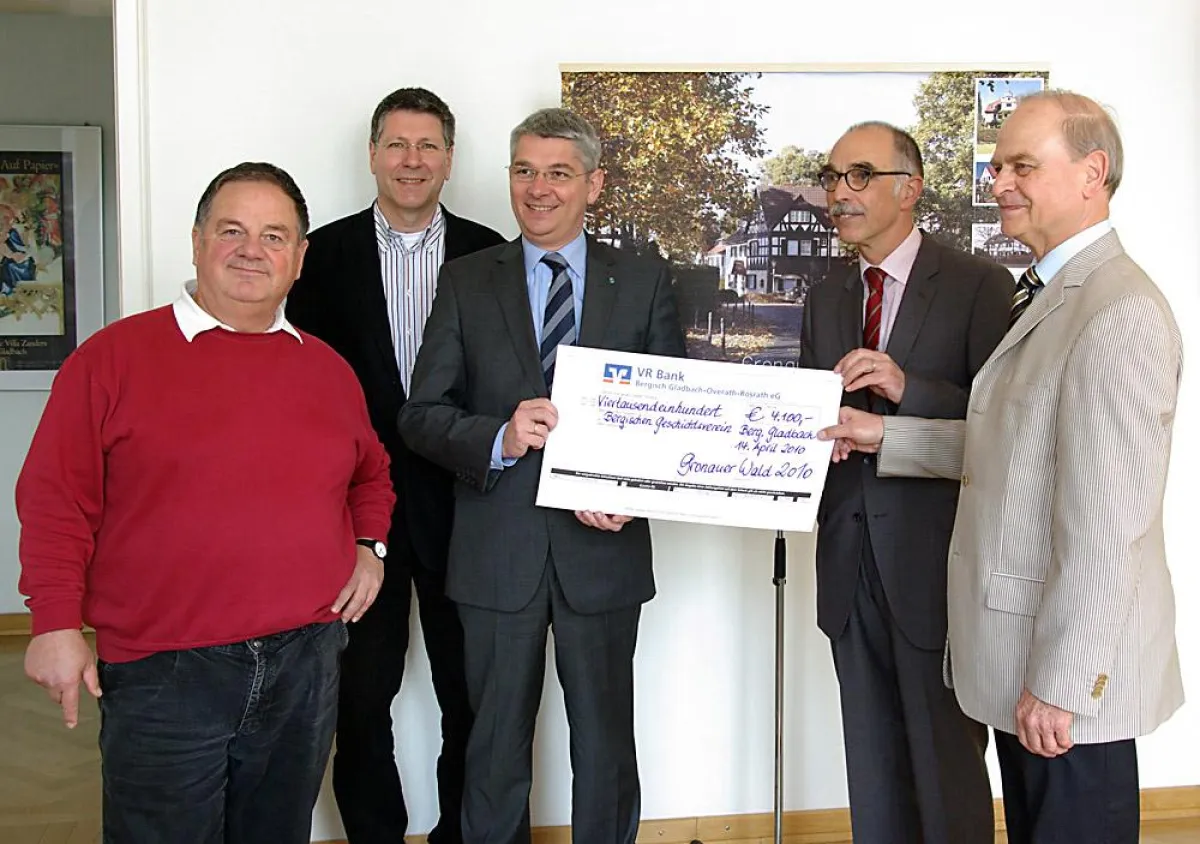 Der symbolische Scheck wurde von Hans Kessell (FGGW, r.) im Beisein von Franz Hardy (VR Bank, 2.v.r) und Max Morsches (Bergischer Geschichtsverein) dem Bürgermeister Lutz Urbach (m.) vor einem Bild de