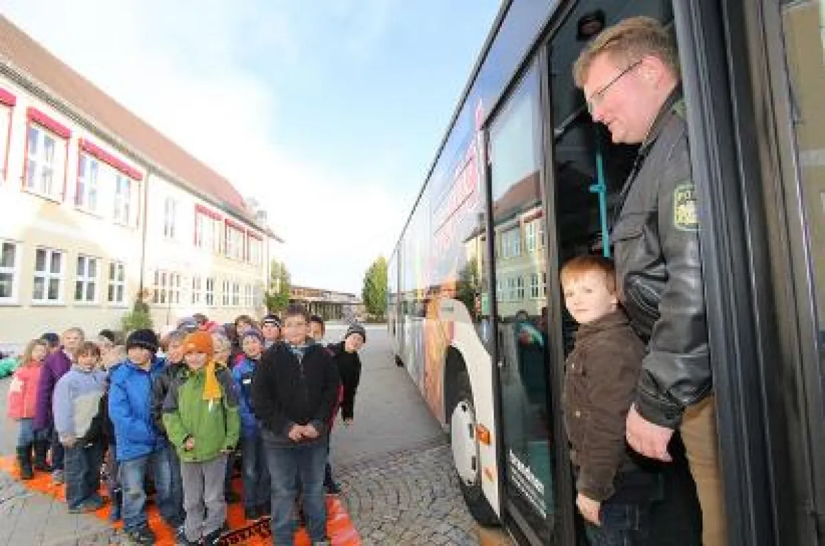 Die Klassen 1a und 2a umringen die Verantwortlichen und Horst, den Dummy in Polizei-Overall.