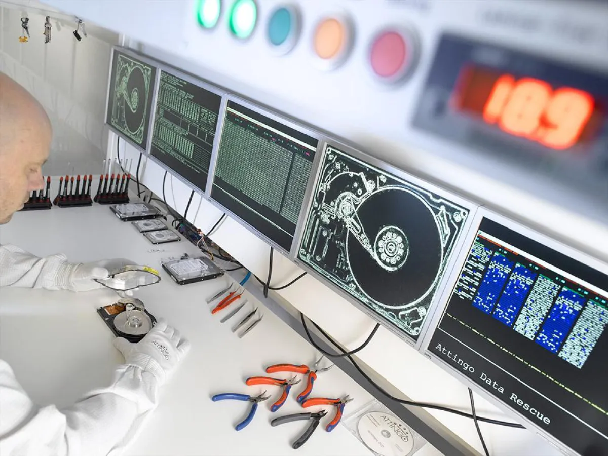 Techniker im Reinraumlabor untersucht eine offene Festplatte