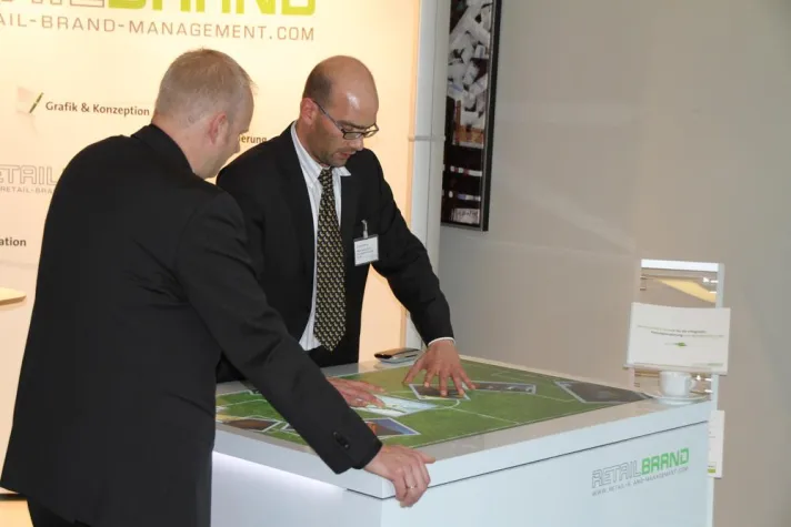 Bild: Multimedialer Präsentationstisch begeistert Kunden am POS