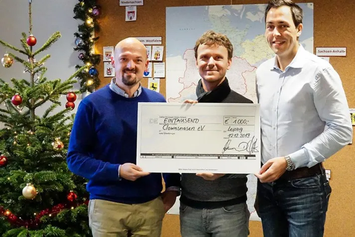 Bild: Ein Lächeln ins Gesicht zaubern: Saxess AG spendet 1000 € an den Clownsnasen e.V.