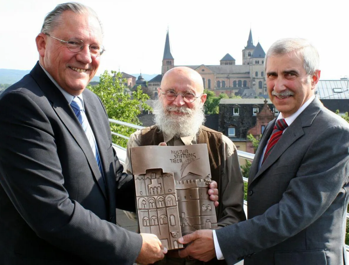 Harry Thiele (li)  überreicht die Stifterplatte 2011 an den Kulturstifter Remigius Kühnen (re., Sparkasse Trier), mi. Künstler Chr