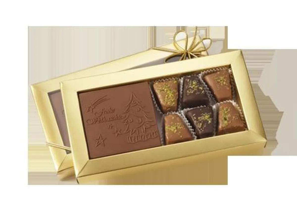 Baumkuchenspitze und ein individuell geprägtes Schokologo in einer goldenen Schachtel. / Foto: Schokologo