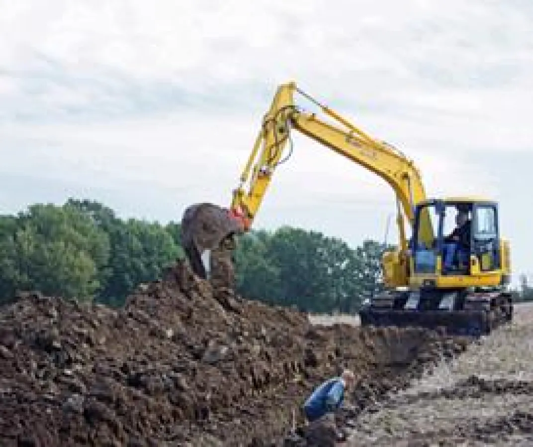Mit Drainagelöffel arbeitet sich der stabile Komatsu PC 138-US-8 aus dem HKL MIETPARK durch den nassen Feldboden.