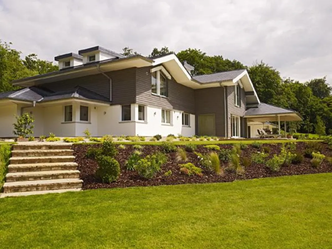 Das ökologische Baufritz-Haus schmiegt sich mit einer Kaskade von Dächern in die Landschaft