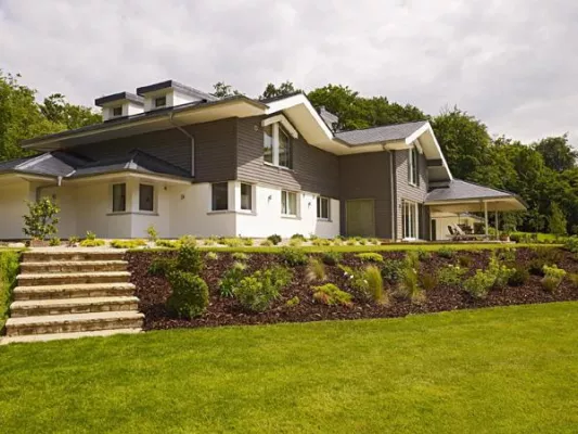 Bild: Das Haus schmiegt sich mit einer Kaskade von Dächern in die Landschaft