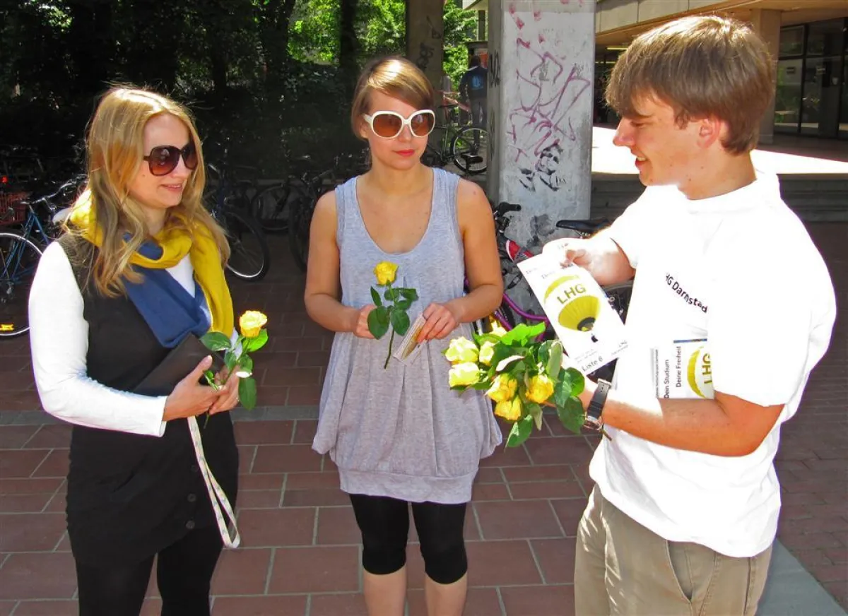 LHG-Kandidat Konstantin Kloos verteilt gelbe Rosen an Architekturstudentinnen