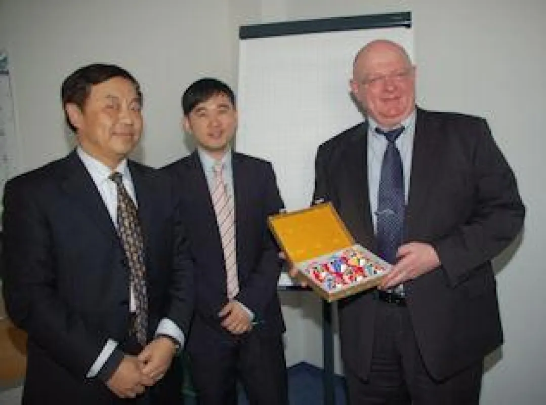 Peter Forscht, CCO der ABAS Software AG, erhält als Gastgeschenk vom Vice Director des Information Office of Henan Provincial People´s Government kleine Masken der Pekinger Oper.