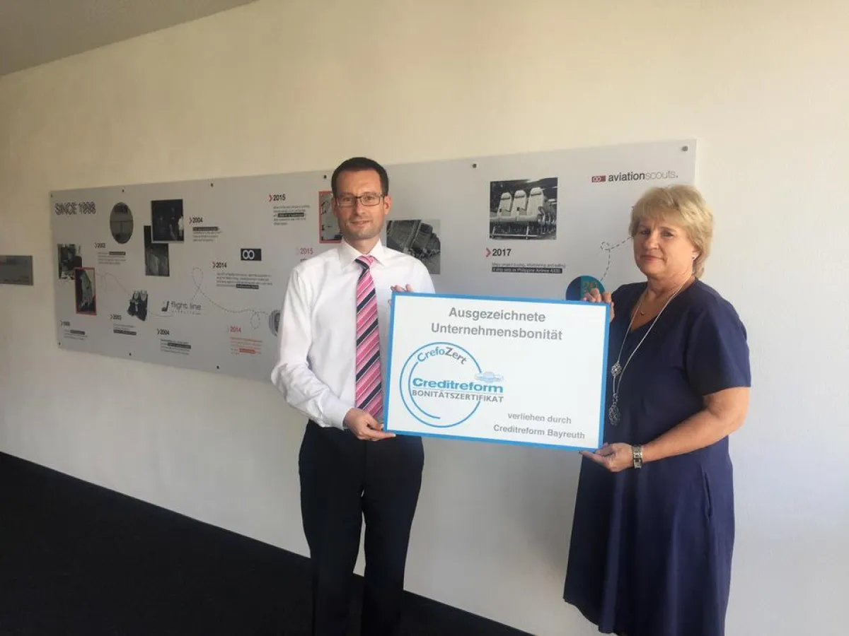 Doris Schuberth (aviationscouts) nimmt Zertifikat von Heiko Büttner (Creditreform) entgegen