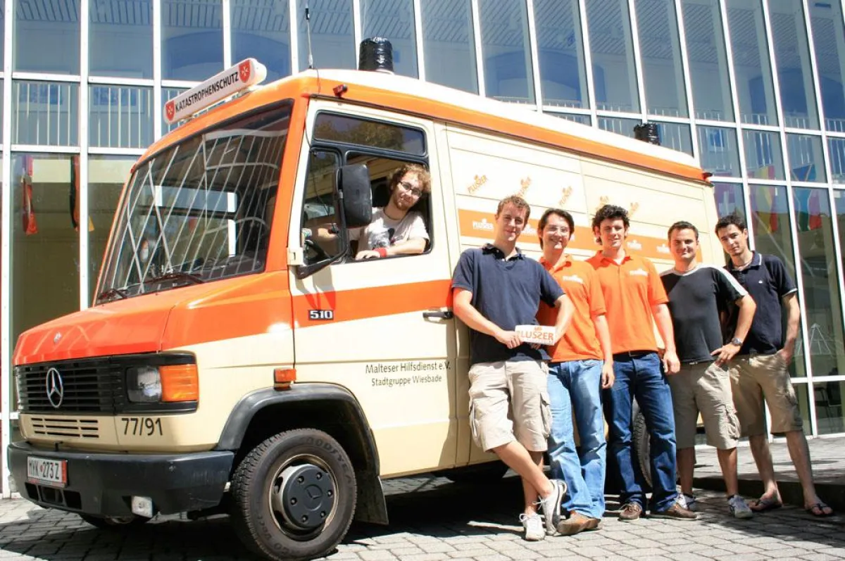Die Plusser.de-Gründer Christian Weiß (4. v. r.) und Jannis Choulidis (3. v. r.) verabschieden Christopher Wicker (2. v. r.) und sein Team vor der 6500 Kilometer langen Reise nach Herat, Afghanistan