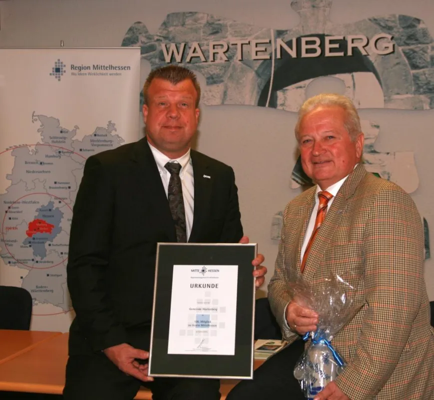 Dr. Lars Witteck überreicht die Begrüßungsirkunde an Manfred Dickel (parteilos), Bürgermeister der Gemeinde Wartenberg
