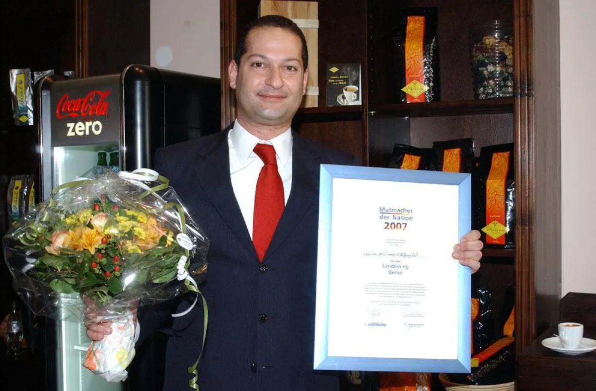 Firmengründer Ozan Taner bei der Übergabe der Urkunde durch die Bürgschaftsbank und den TVG Verlag