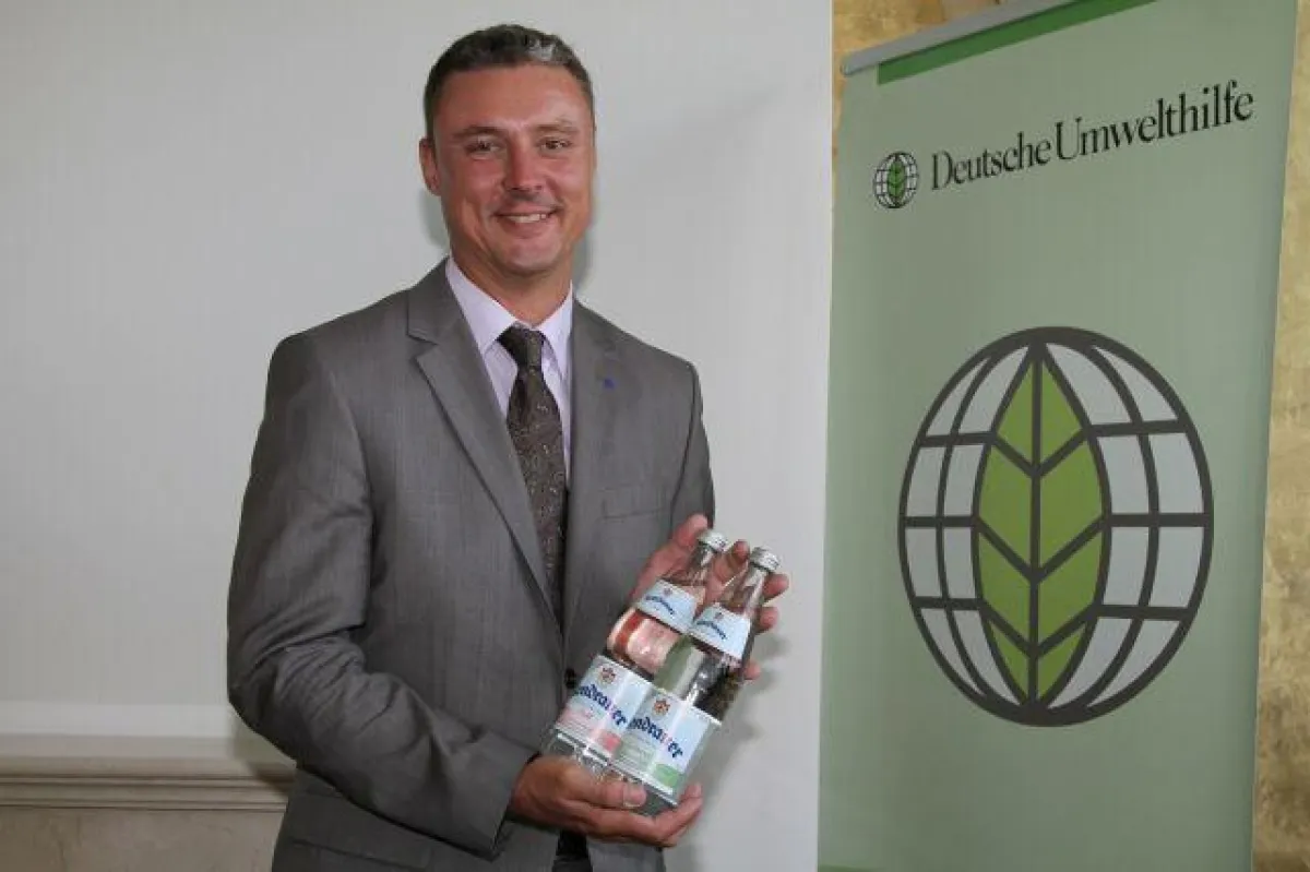 Kondrauer-Geschäftsführer Markus Humpert mit der prämierten Leichtglasflasche    (Quelle: DUH/Kisorsy)