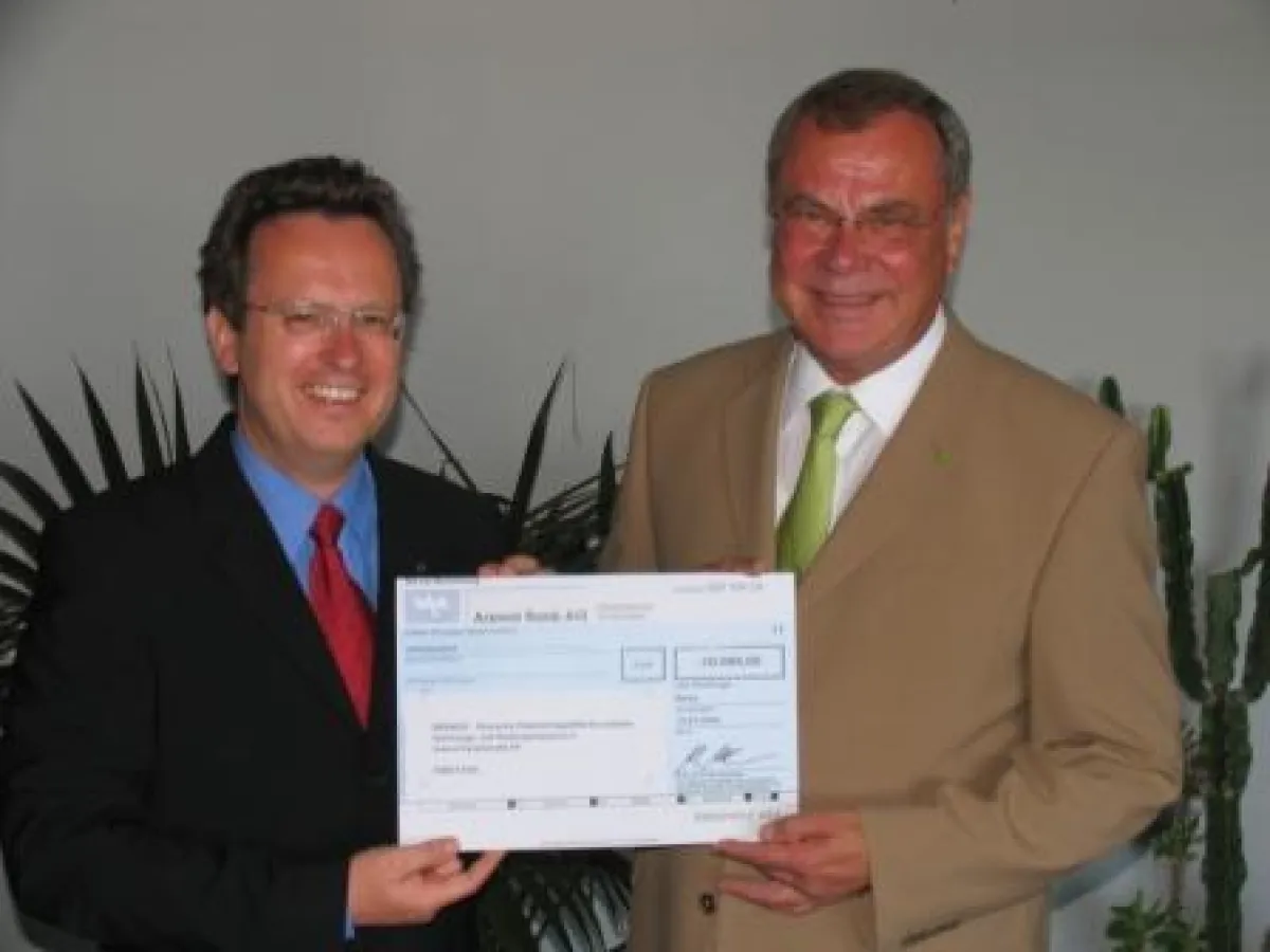 Dr. Manfred Alflen (li.) übergibt die Spende für das Trinkwasserprojekt an Georg Potschka (re.).