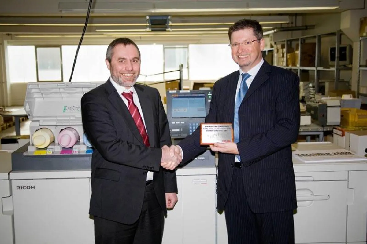 Reinhold Link (rechts, Ricoh Deutschland) überreicht Werner Neumann (geschäftsführender Gesellschafter von dataform) den Pro C900-Award.