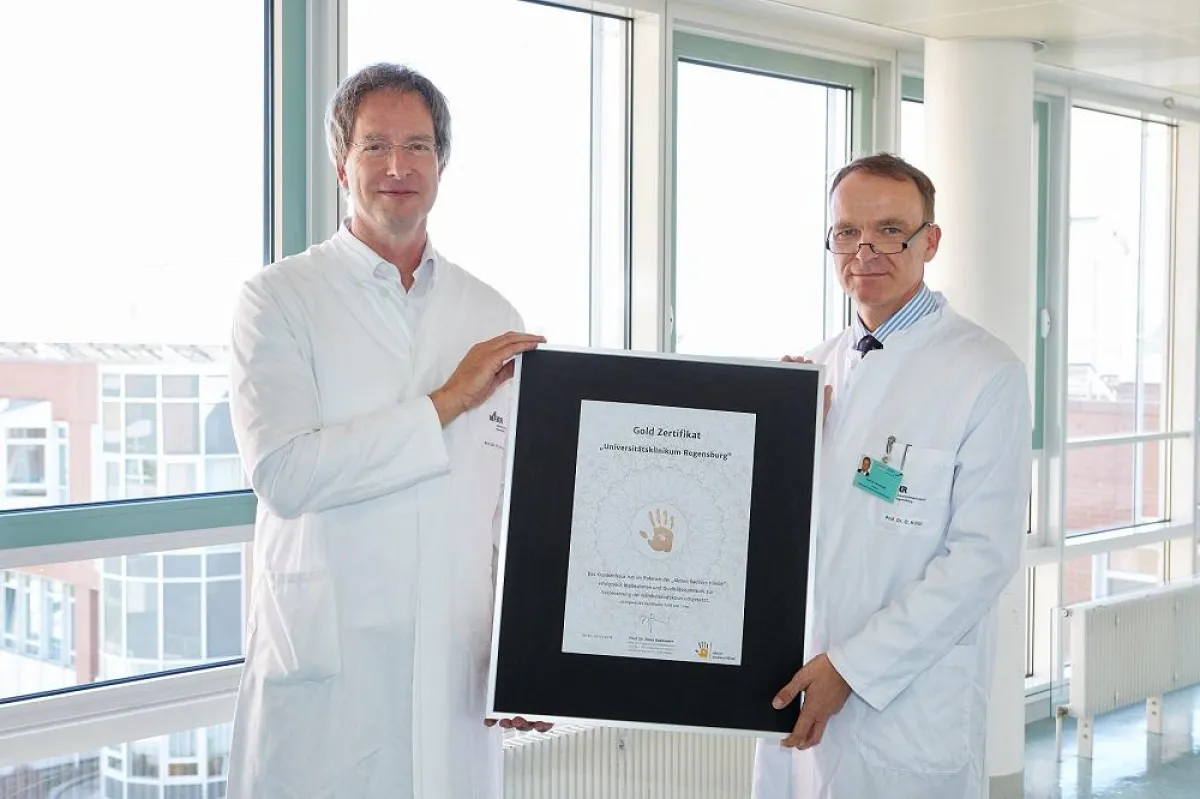 Prof. Dr. W. Schneider und Prof. Dr. O. Kölbl mit dem Gold-Zertifikat. © UKR / Johannes Beutler