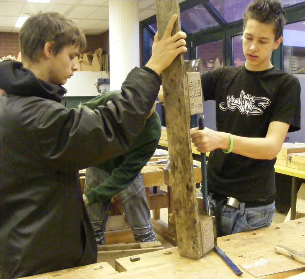 Kratzbaum-Schüler bei der Palettenreparatur