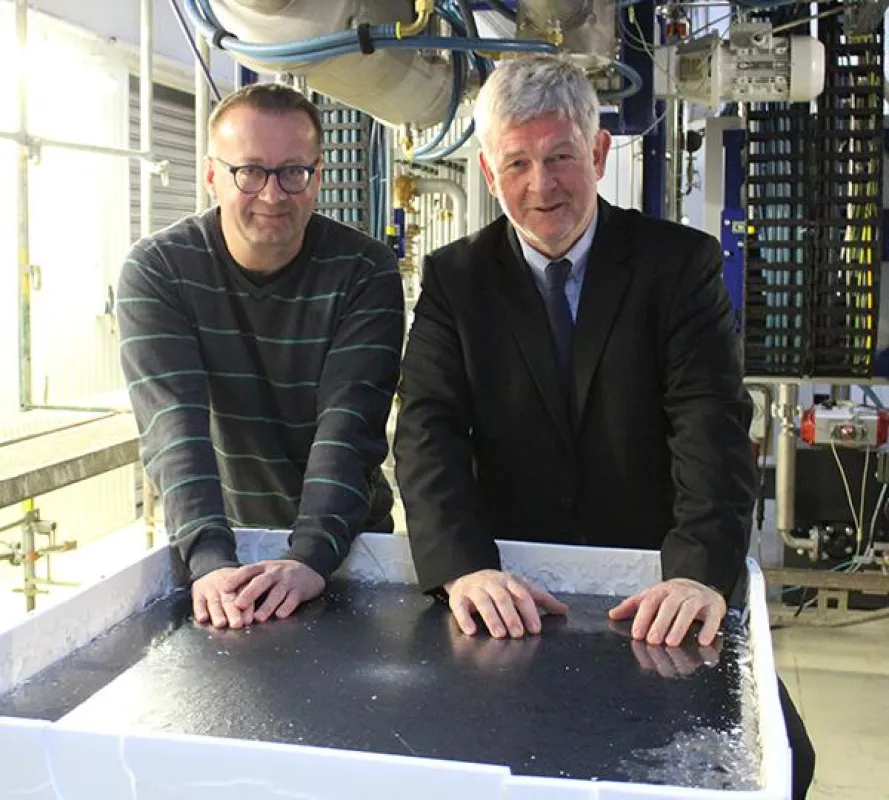 Die beiden Geschäftsführer Dr. Ingo Röver und Ulrich Loser (v. l.) mit dem ersten Silicium Block