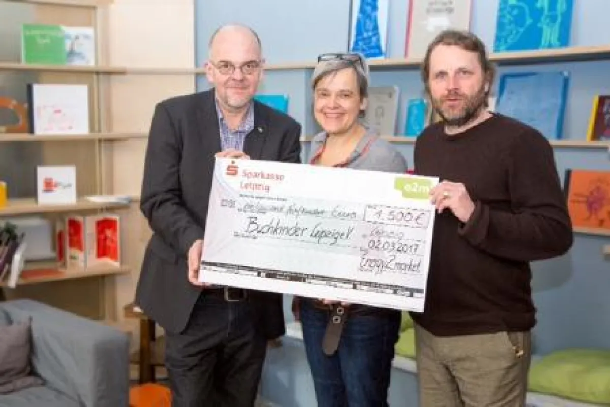 Michael Richter, Marketingleiter der e2m (l.i.B.), überreicht den symbolischen Spendenscheck.