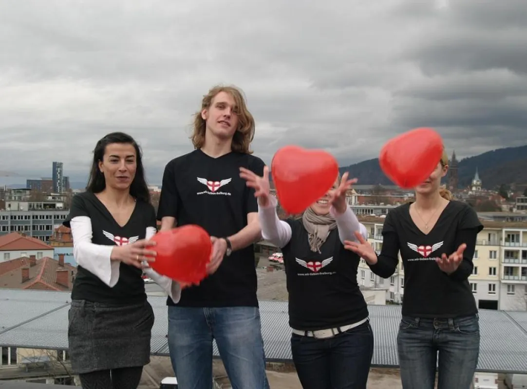 Ein Teil des Teams von wir-lieben-Freiburg.de über den Dächern von Freiburg mit den neuen T-Shirts aus dem Online-Shop.