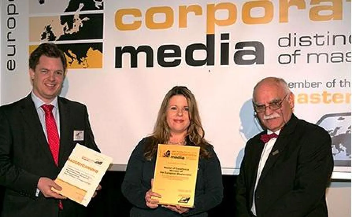 Projektleiterin S. Conen (Mitte) nimmt die Awards von R. G. Lehmann (r.) und A. Marx (lks.) entgegen
