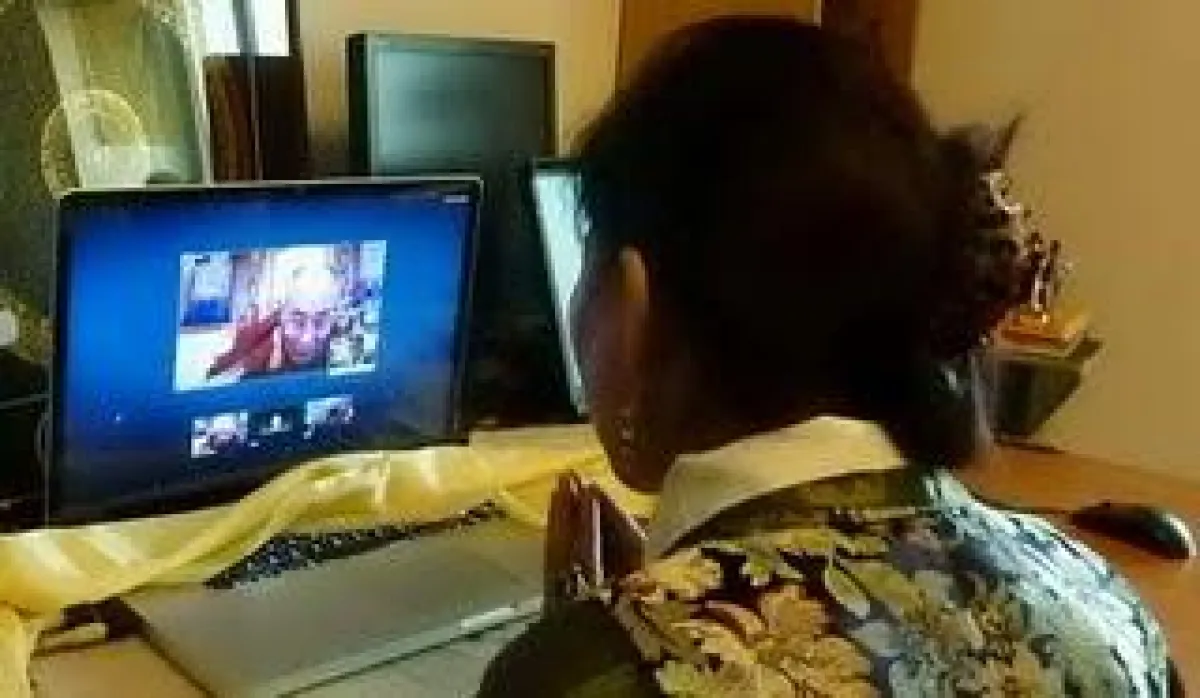 Woeser vor dem Bildschirm, auf dem der Dalai Lama spricht