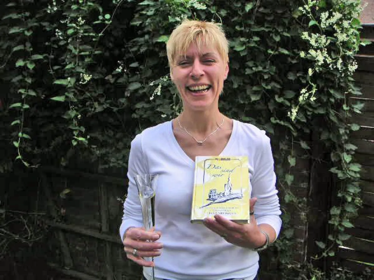 Liane Neumann präsentiert das erste Buchexemplar. Im virtuellen Forum feiern alle mit.