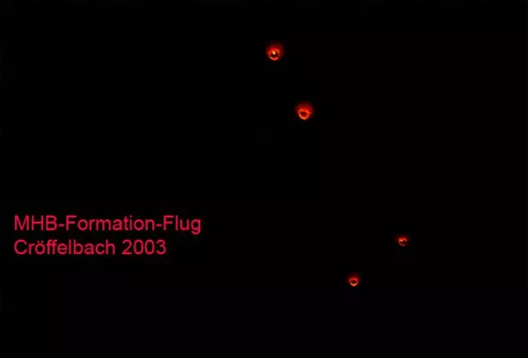 Orange-rote Lichtugeln in warmen Farbtönen und ´Aura´ als 'Cluster' oder Flotte am Silvernachthimmel unterwegs Bild: Orange-rote Lichtugeln in warmen Farbtönen und ´Aura´ als 'Cluster' oder Flotte am Silvernachthimmel unterwegs