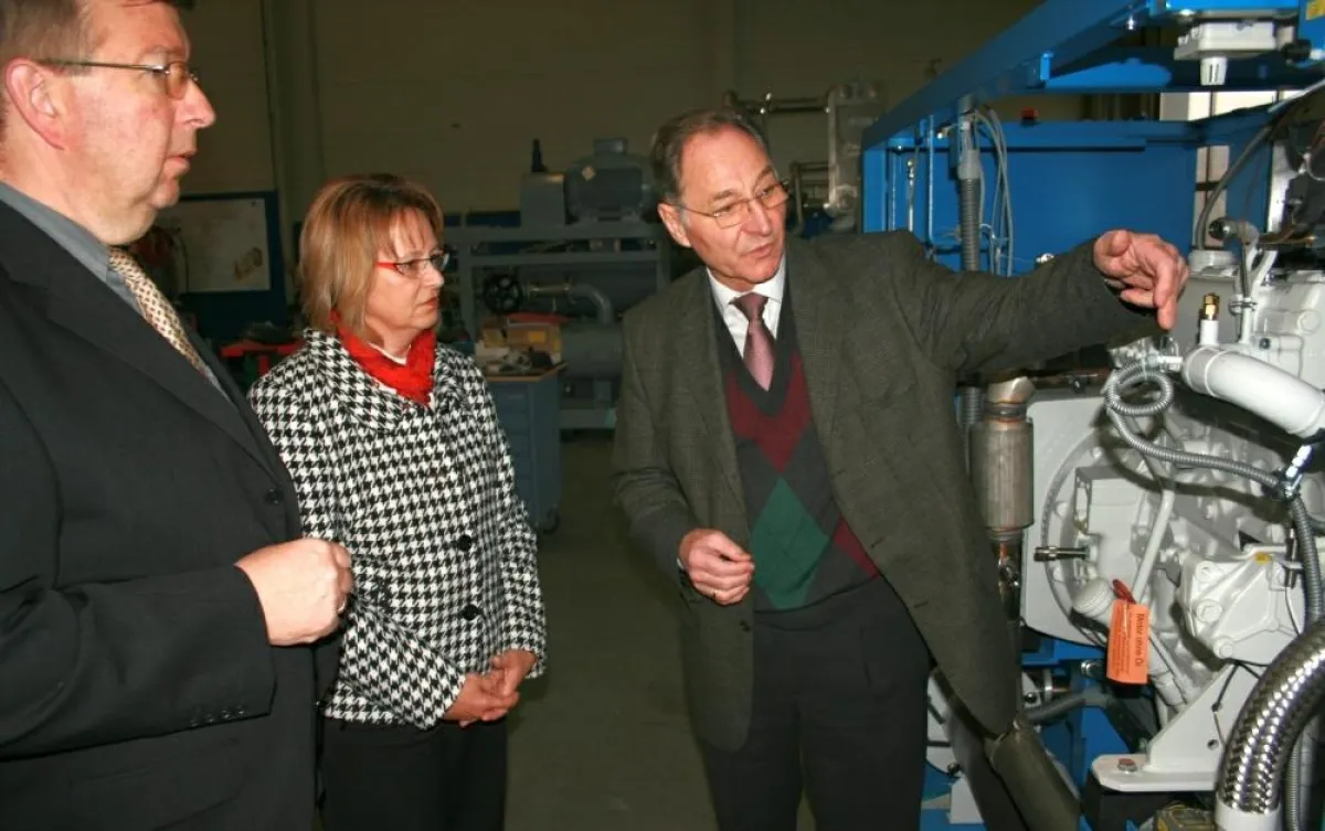 Helmut Ziegler erläutert Beate Hammerla und Burghard Loewe ein Blockheizkraftwerk (von rechts)