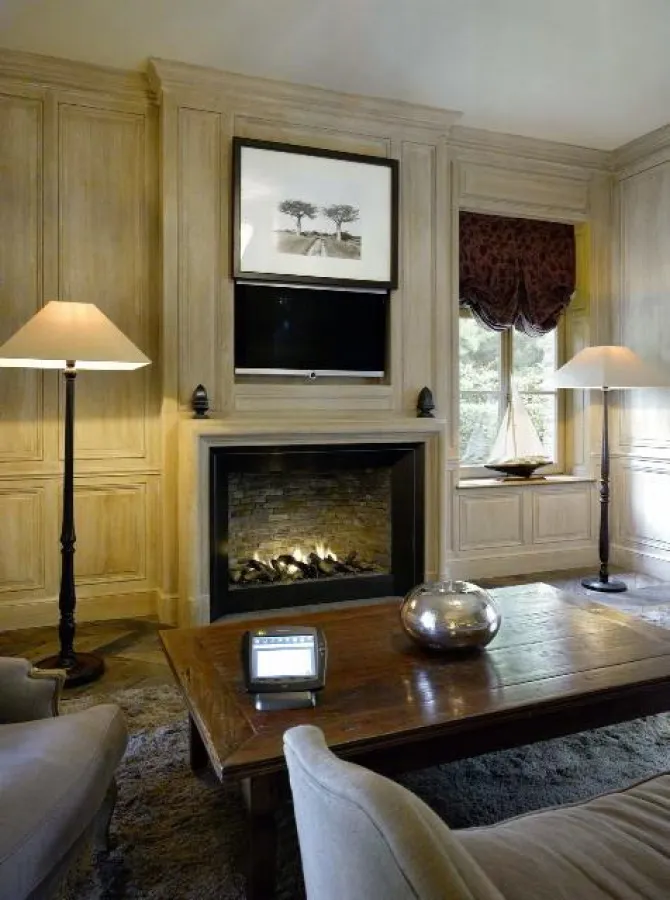 TV hinter Bilder-Lift und unsichtbare Lautsprecher sind in der Holzvertäfelung eingelassen.