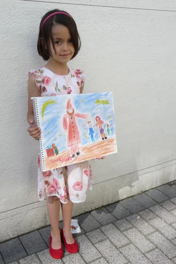 Isra El-Halimi mit dem Adventskalender-Bild des Ambulanten Kinderhospizdienstes Düsseldorf