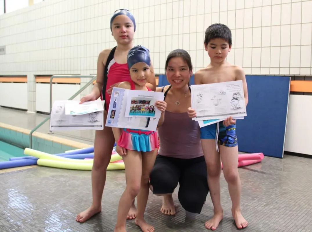 Allison, Egon und Rosa präsentieren zusammen mit ihrer Mutter stolz ihre „Schwimmurkunde“