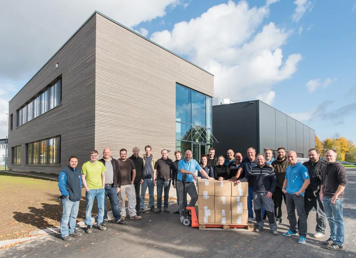 Die Geschäftsführung und Mitarbeiter der primeLine Unternehmensgruppe vor dem neuen Firmengebäude.