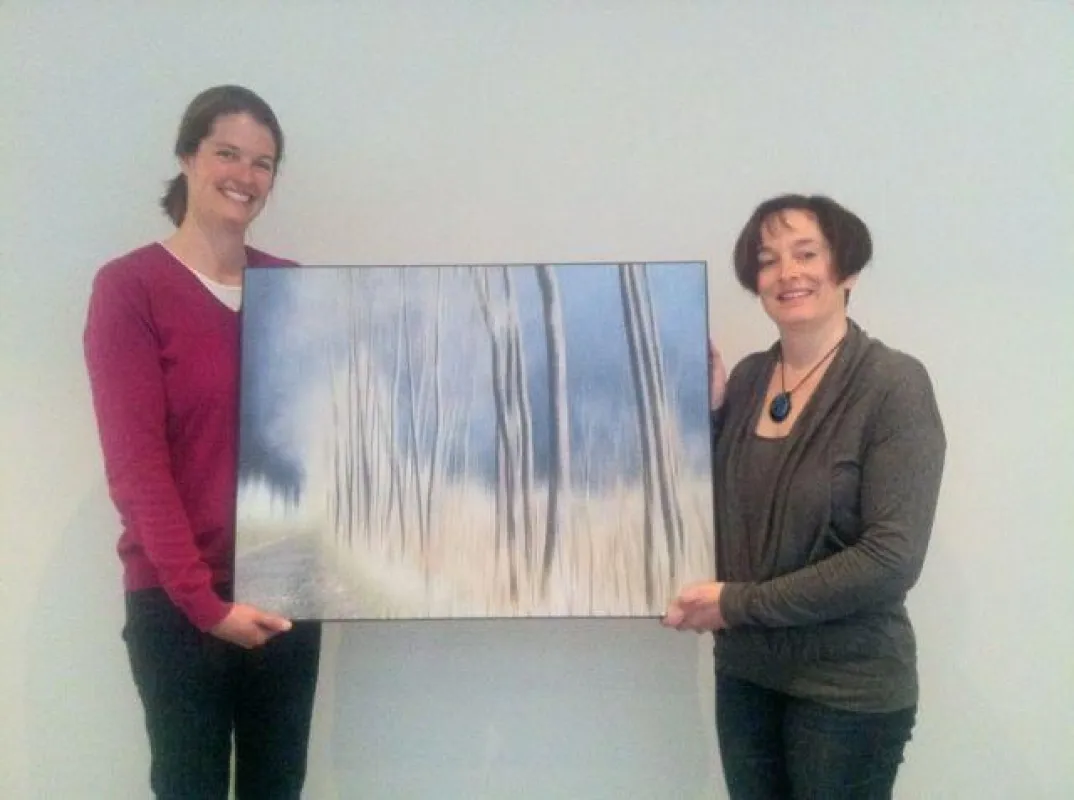 Geschäftsführerin Kristina Schmid mit Künstlerin Ursula Fleiß vor dem Kunstwerk ?Foto-ART?