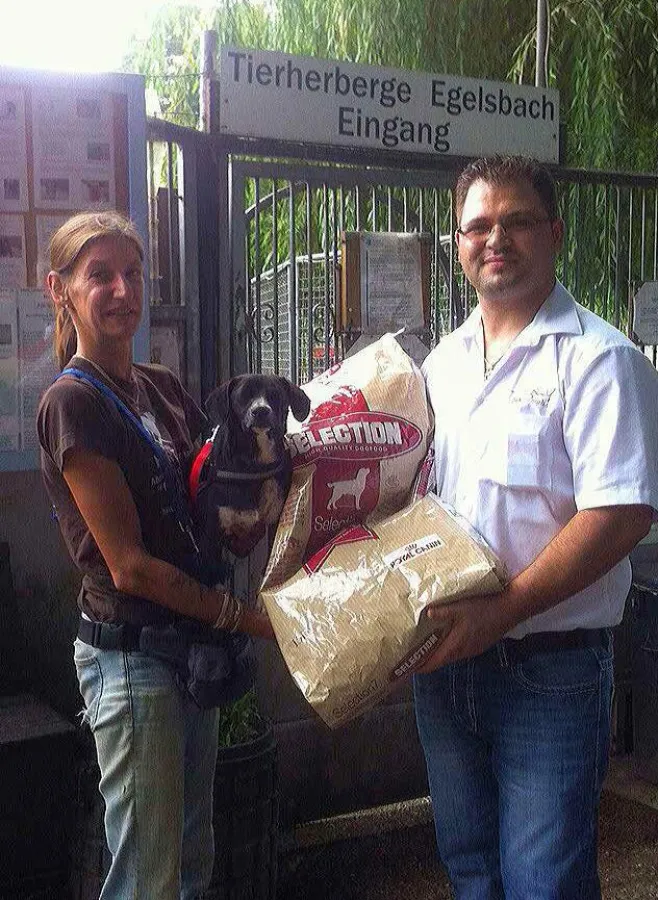 Herr Romano von Pax Animalis übergibt einem der Bewohner einen der Futtersäcke