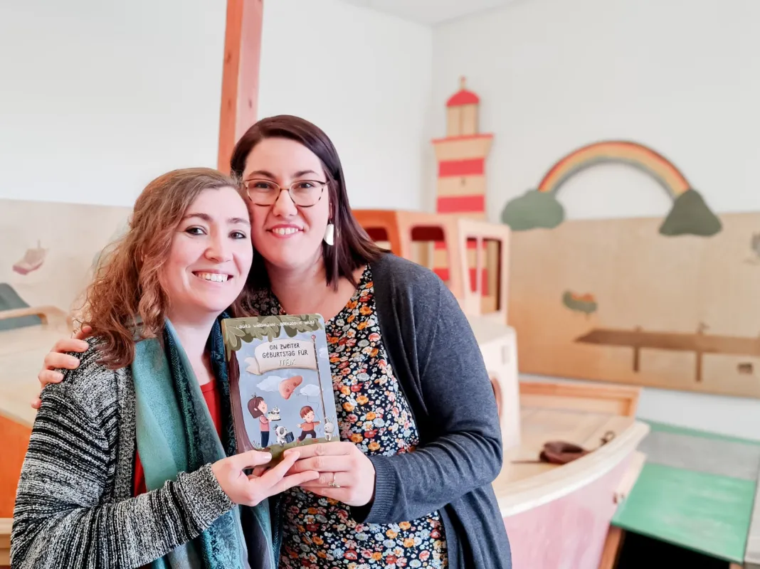 v.l.: Laura Wiedmann (Text) und Bernadette Wilbs (Illustration) mit ihrem gemeinsamen Werk  (© Verein Leberkrankes Kind e.V.)