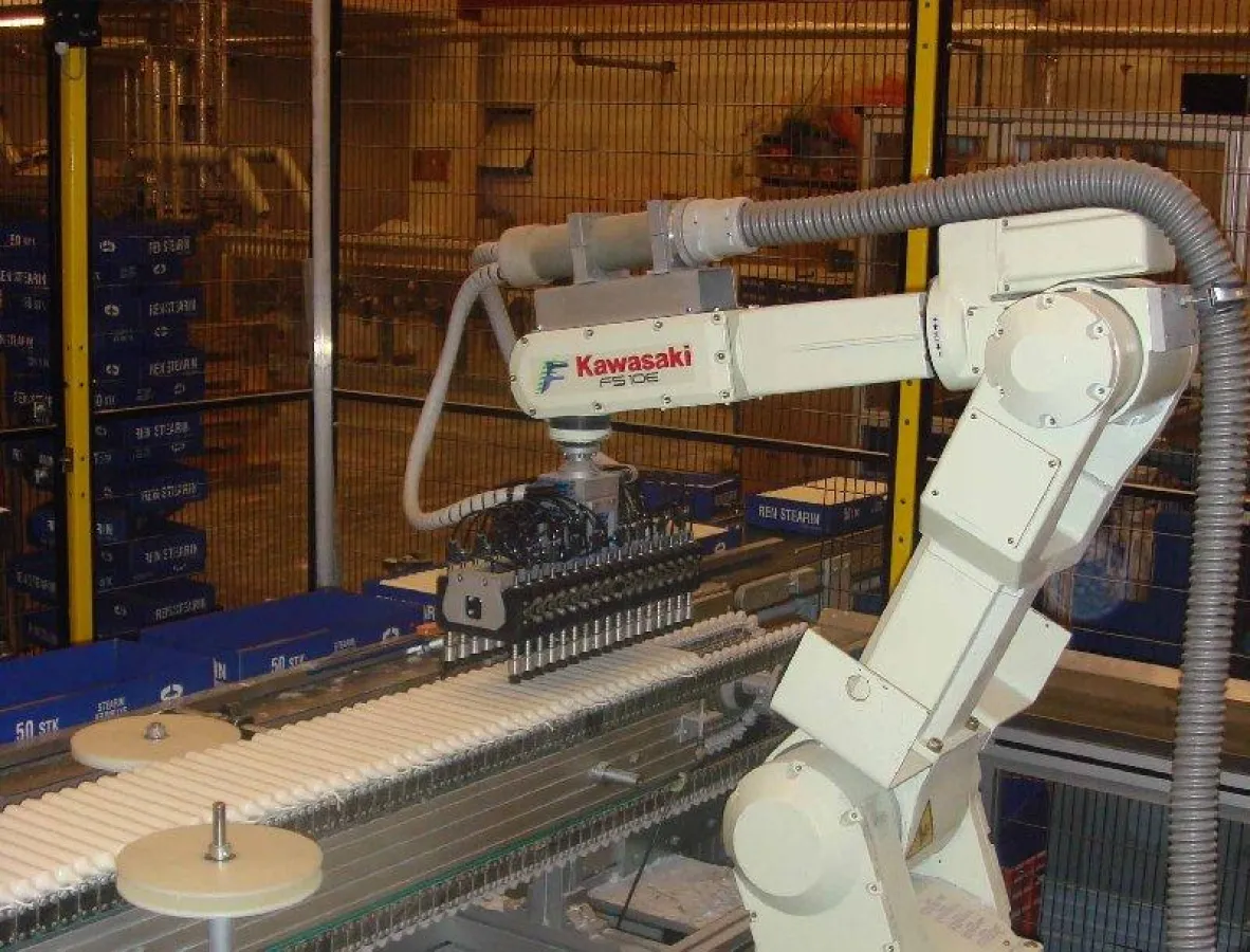 Die fertigen Kerzen und Verpackungen laufen auf zwei Bändern parallel zur Verpackungsstation