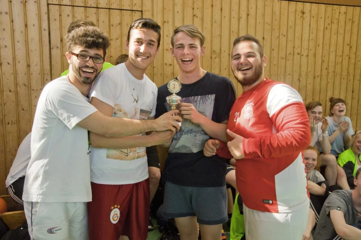 Mohammad, Furkan und Jilber aus Jg. 11 überreichen als Abschiedsgeschenk ihren Pokal