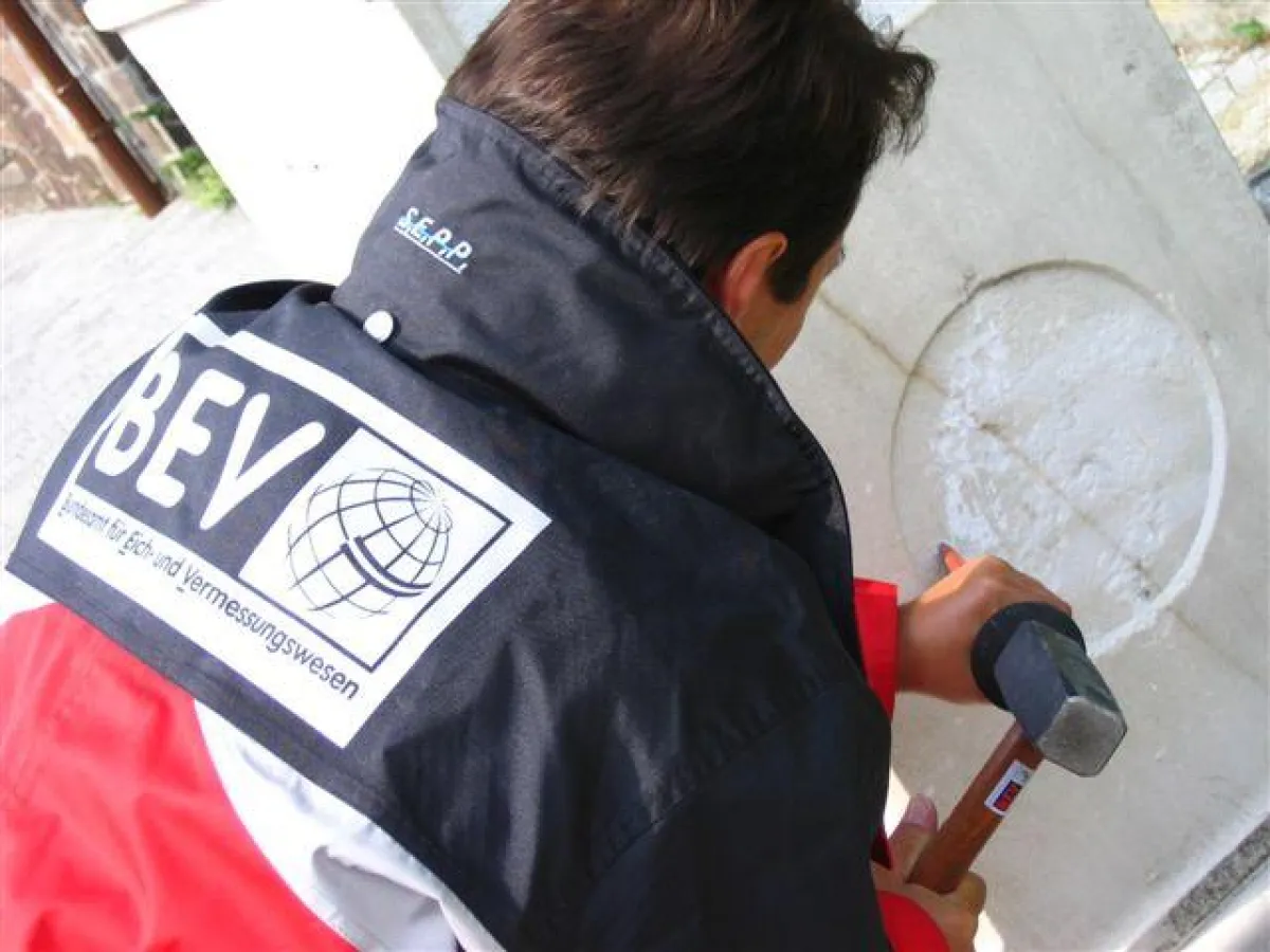 Ein Mitarbeiter des Bundesamtes für Eich- und Vermessungswesen entfernt das Hakenkreuz