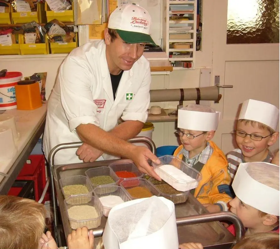 Fleischermeister Dirk Ludwig lässt Kindergartenkinder in seiner Metzgerei Gewürze schmecken und erleben