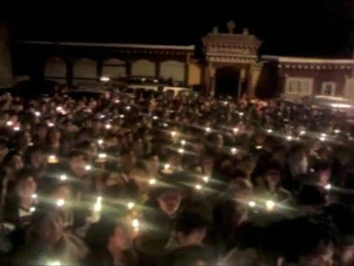 Tibeter in Tawu trauern um Palden Choetso und halten Kerzen in der Hand