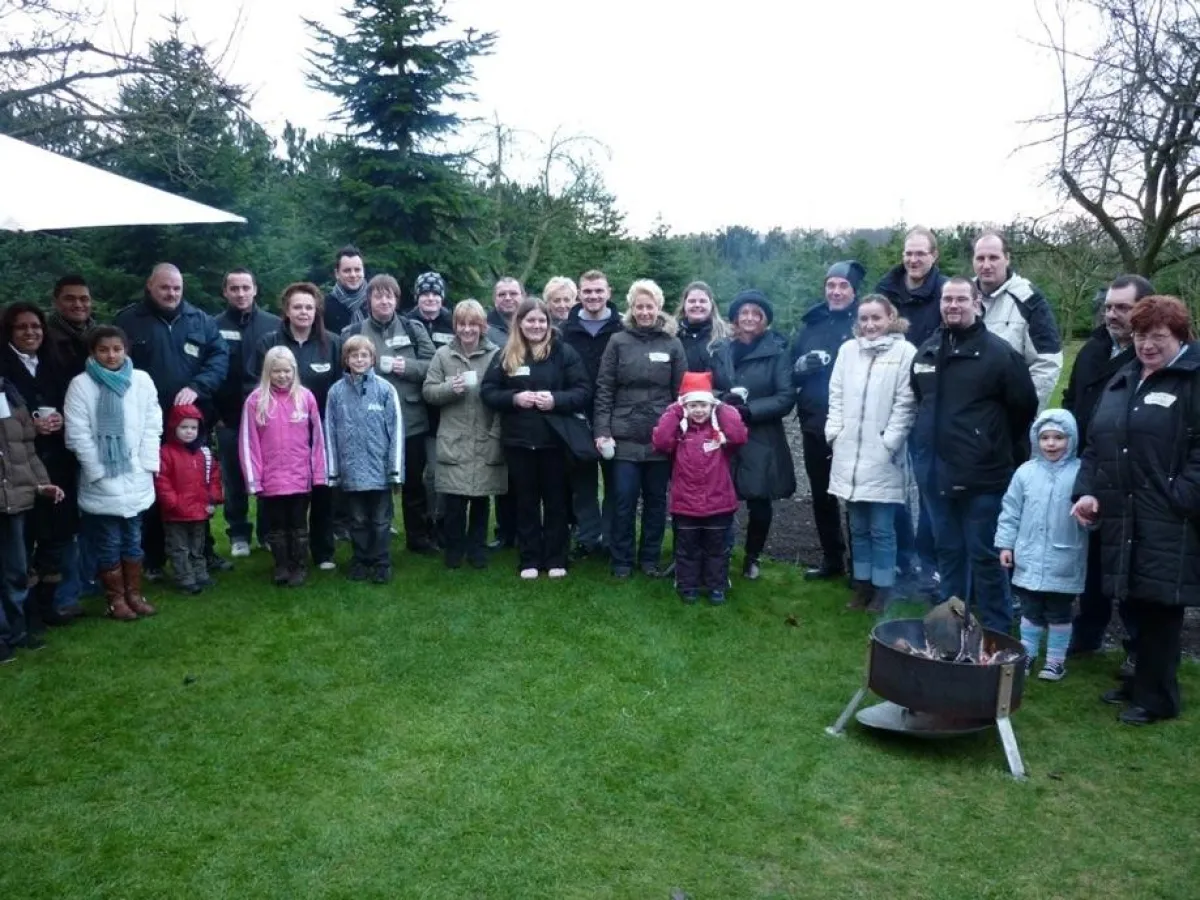 ruhrmed-Mitarbeiter nach getaner Holzfällerarbeit beim verdienten Glühwein.