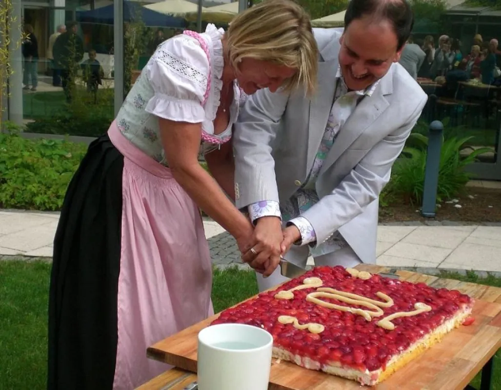 Direktorin Gabriele Seegerer und ihr Vorgänger, Udo Stürmer, schneiden den Geburtstagskuchen an.