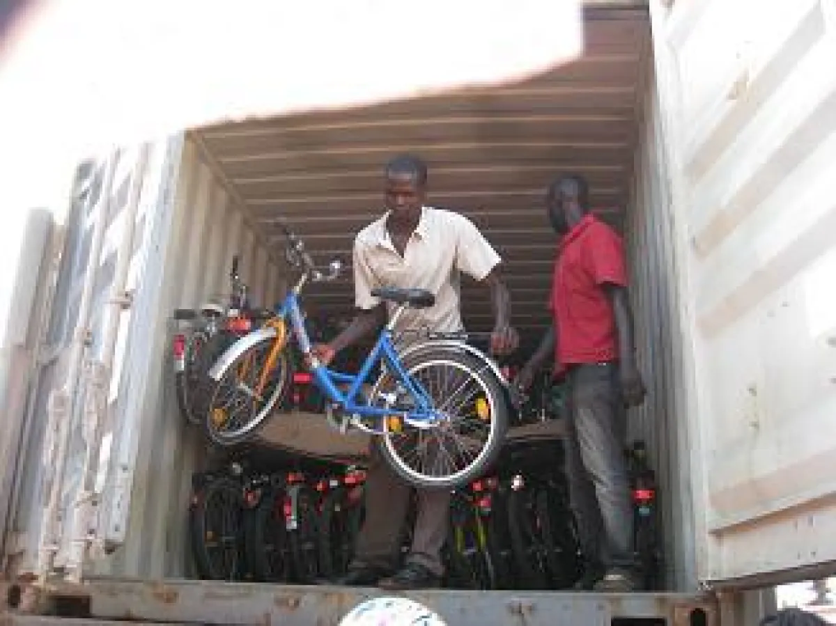 Mitarbeiter der Organisation FABIO laden die gespendeten Kinderfahrräder aus dem Container