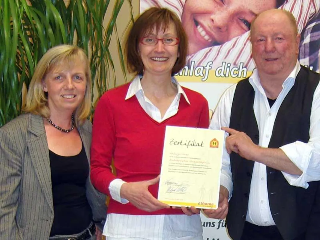 athome-Gründerin Annemarie Heuer (l.) und Ausbildungsleiter Wilfried Gellrich (r.) begrüßen die neue Standortexpertin Walburga Frewer.