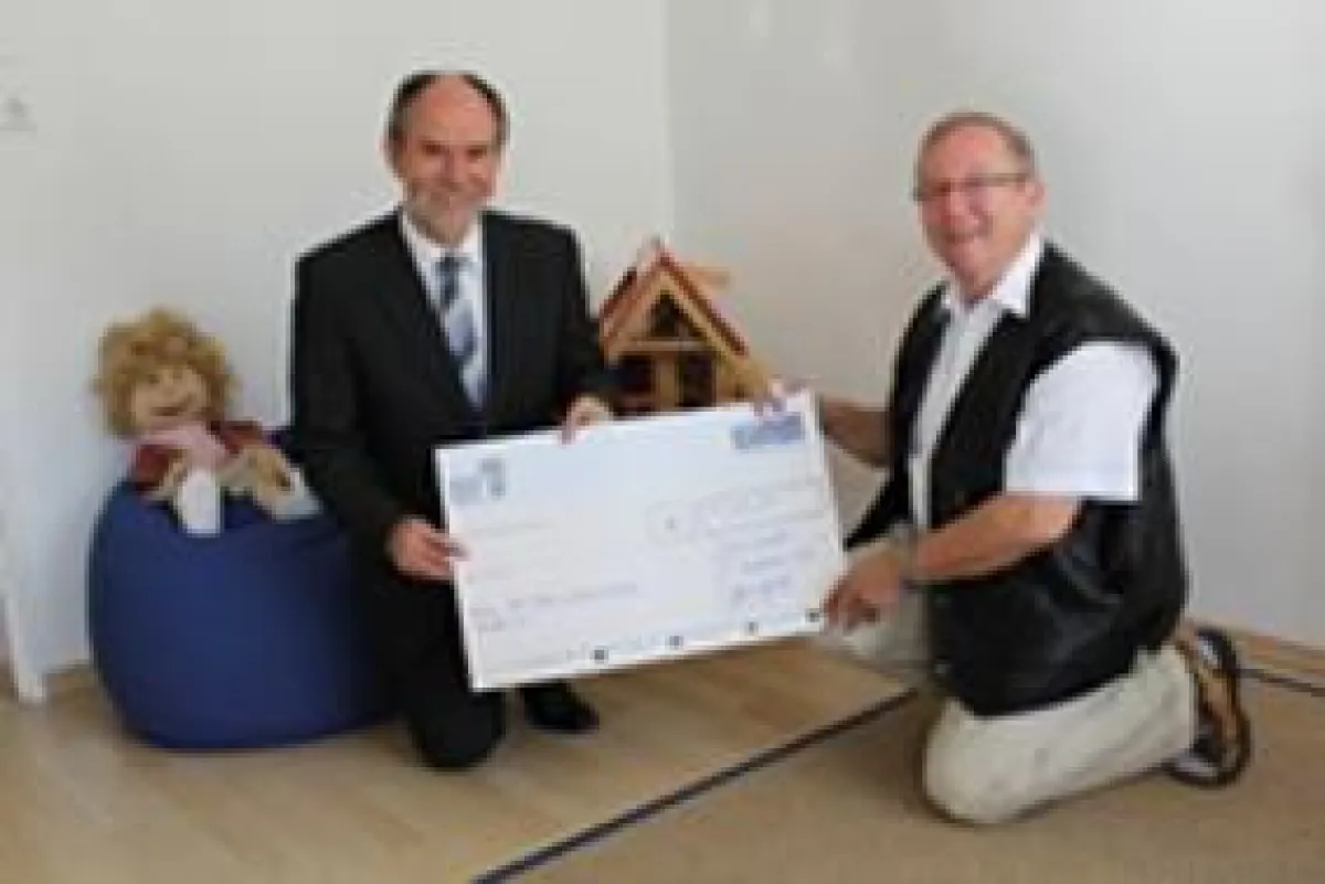 Dr. Burkhard Austermühl überreicht die Spende an Gerd Grünewaldt vom Verein für krebskranke und chronisch kranke Kinder