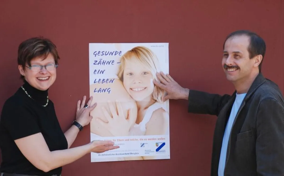Dr. Alexandra Reil, Referentin für Zahnärztinnen im Beruf, und Dr. Ingo Lang, Referent für vorbeugende Zahnheilkunde beim ZBV Oberpfalz, präsentieren das Plakat zur Informationskampagne.