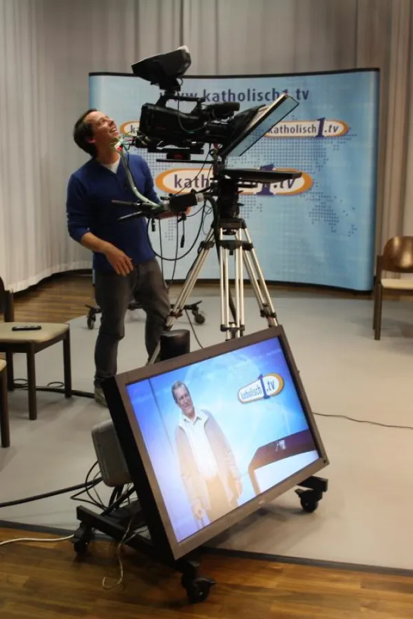 Nico Romberg filmt Pater Blaser vor der Kulisse des Magazins von katholisch1.tv