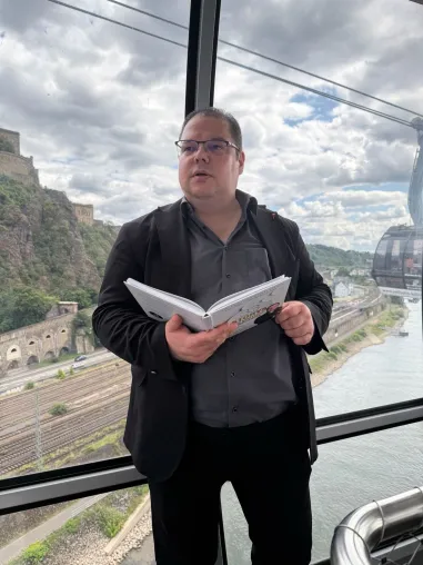 Bild: „33 Experten lesen in der Seilbahn – ein Bestseller, ein Weltrekord und ein emotionales Highlight in Koblenz.“